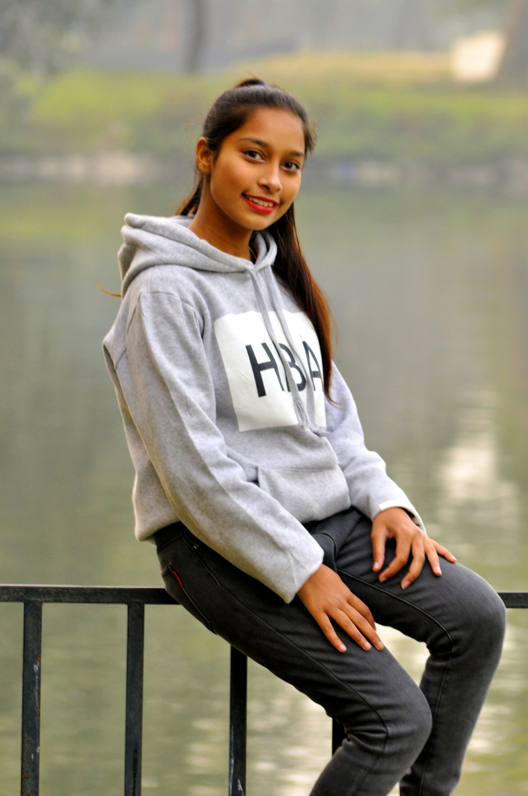 woman in gray hoodie sitting on black wooden bench